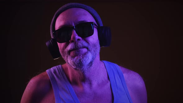 Senior man in headphones dancing and singing
