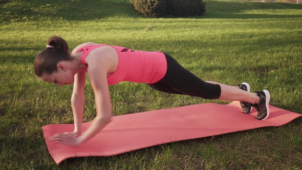 Fitness Woman Doing Dynamic Plank Exercise on Grass, Sunny Summer Day