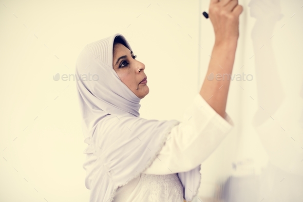 A Muslim teacher writing on a white board Stock Photo by Rawpixel | PhotoDune