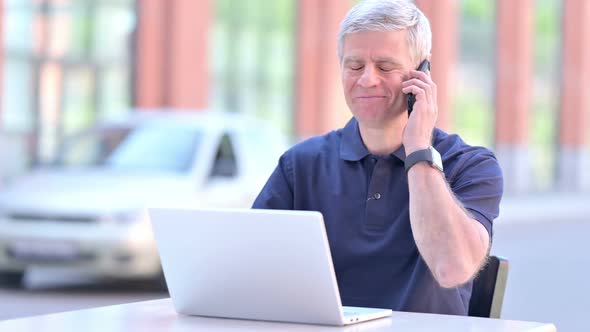 Outdoor Ambitious Middle Aged Businessman Taking on Smartphone alt