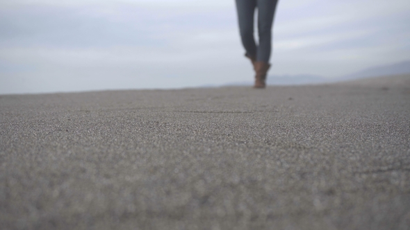 The Girl Is Walking Along the Sand