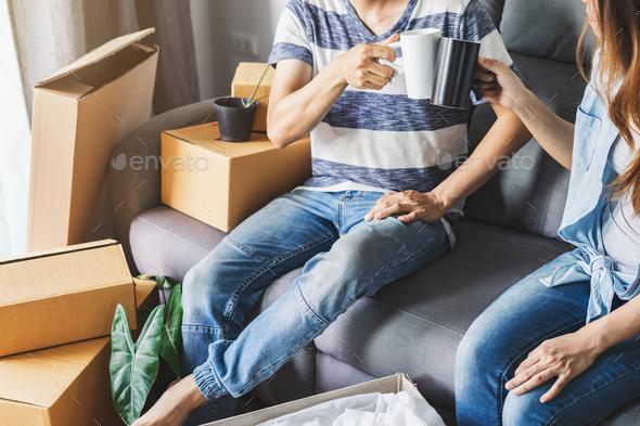 Young happy couple moving in new home, sitting and relaxing on sofa Stock Photo by kitzstocker