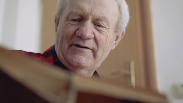 Happy Old Man Reading Book with Positive Smile alt