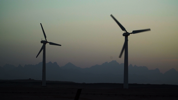 Beautiful Windmill Turbines Harnessing Clean, Green, Wind Energy Silhouetted in the Sunset Sky with alt