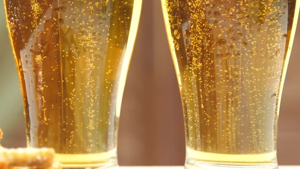 Two Glasses of Light Beer with Bubbles and Foam alt