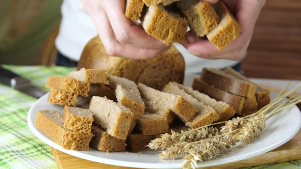 Hands Put Pieces of Bread on a Plate alt