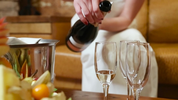 Woman's Hands Pour Champagne into Glasses alt