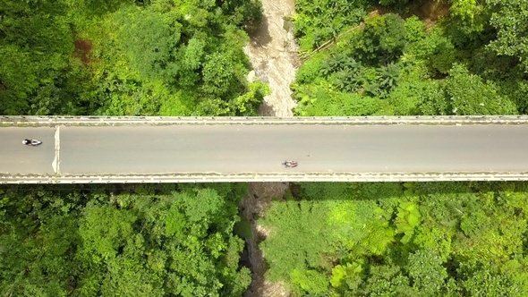 Cars and Motorbikes Traffic on Bridge Road Over Mountain River in Tropical Rain Forest