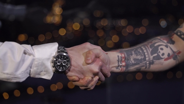 Handshake Between Clear and Tattooed Hands