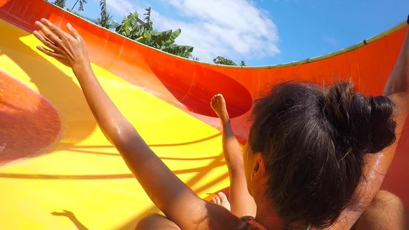 Young Mixed Race Couple Having Fun Riding down in a Water Slide alt