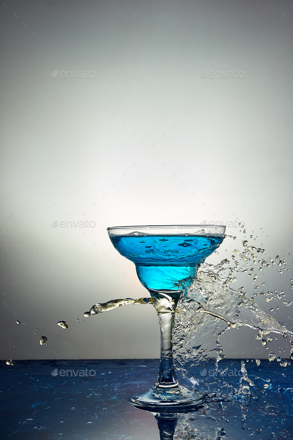 Glass with blue champagne or cocktail. Levitation Stock Photo by bondarillia