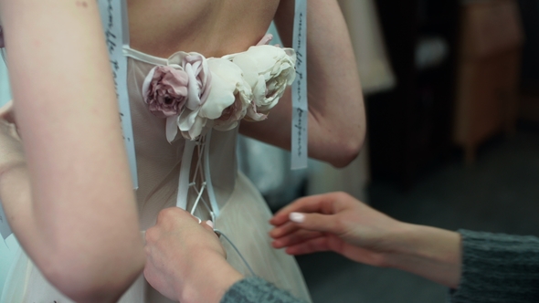 Stylist Helps To Tighten the Corset of a Historical Dress on Woman. Back View alt