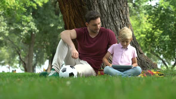 Father Watching Son Playing Game on Tablet, Entertainment of Digital Generation alt