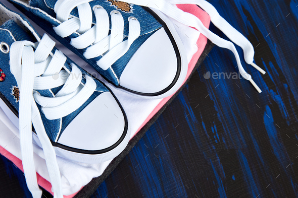 Flat lay of female sneakers shoes and tee Stock Photo by bondarillia