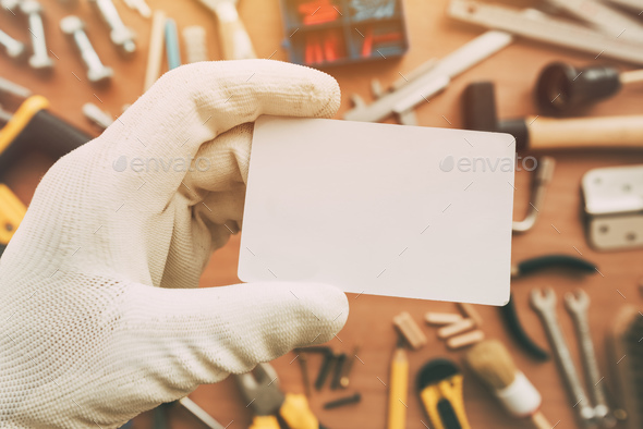 Worker holding blank business card as copy space Stock Photo by stevanovicigor