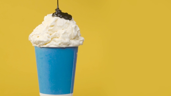 Rotating Soft Vanilla Ice Cream in Blue Paper Cup with Chocolate Sauce