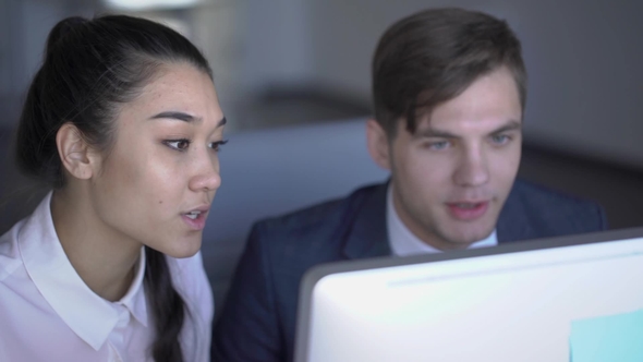 Asian Businesswoman and Caucasian Businessman Discussing the Project on Computer in the Office alt