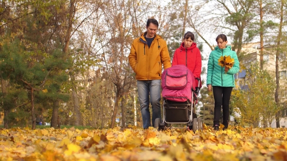 Family Couple with Teenage Girl and an Infant on Way to Park