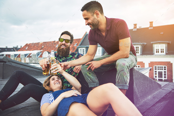 Three adults enjoying beer and friendship - Stock Photo - Images