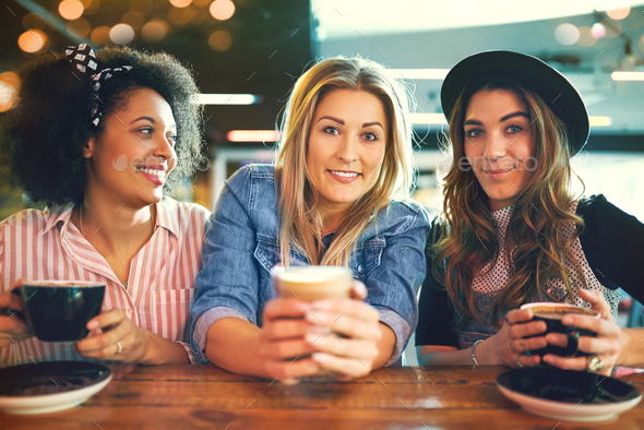 Three trendy young women enjoying coffee Stock Photo by FlamingoImages