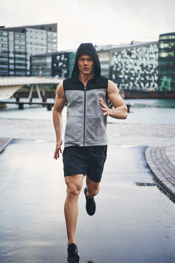 Sportive and healthy male running down street - Stock Photo - Images