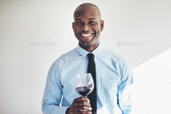 Smiling mature man drinking a glass of red wine - Stock Photo - Images