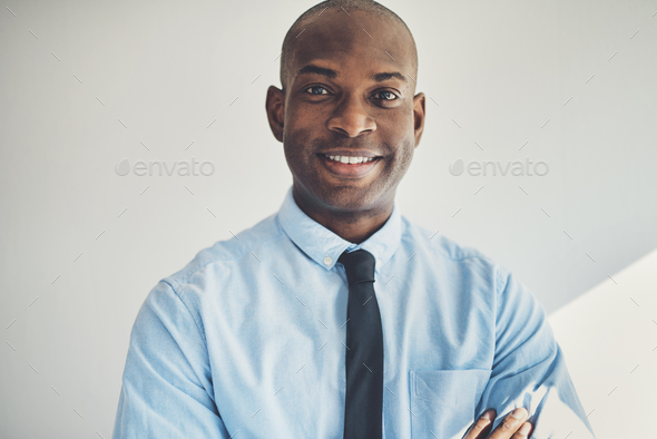 Mature businessman standing with his arms crossed in an office - Stock Photo - Images