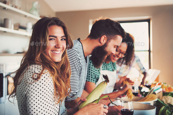 Happy woman preparing food at table in kitchen - Stock Photo - Images