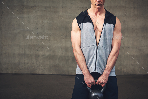 Crop sportive man having workout with kettlebell - Stock Photo - Images