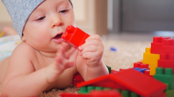 Small Kid Boy Plays in the Constructor, Sitting at Home on Floor alt