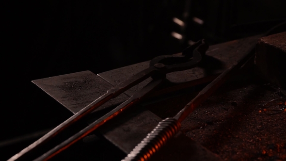 Blacksmith Fanning the Flames of the Furnace Using the Tools Prevents Embers alt