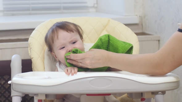 Baby Is Capricious and Crying Sitting on the Highchair in Kitchen alt