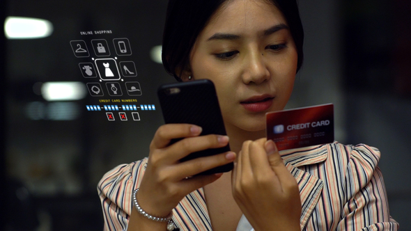 Asian Teenage Girl Using a Mobile Phone to Buy Online Products alt