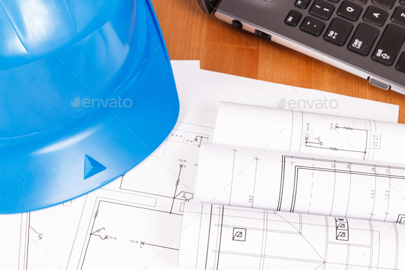 Electrical blueprints or diagrams with laptop and protective blue helmet, technology concept - Stock Photo - Images