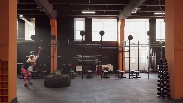 Fitness Woman Doing Sledgehammer Swing Workout at Gym in Backlight alt