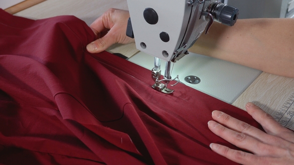 The Seamstress Sews on an Industrial Sewing Machine alt