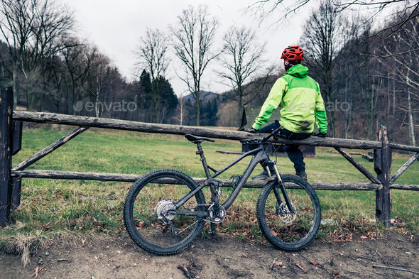 Mountain biker cycling on trail in woods - Stock Photo - Images