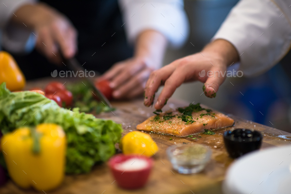 Chef hands preparing marinated Salmon fish - Stock Photo - Images