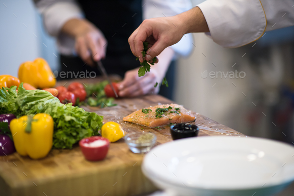 Chef hands preparing marinated Salmon fish - Stock Photo - Images