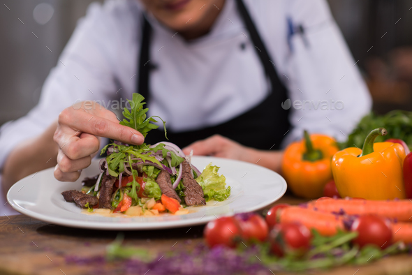 cook chef decorating garnishing prepared meal - Stock Photo - Images