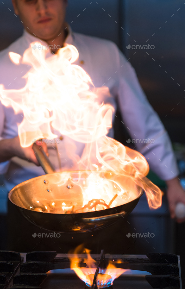 Chef doing flambe on food - Stock Photo - Images
