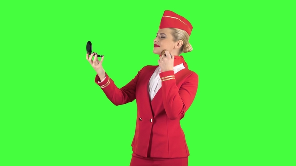 Stewardess Looks in the Mirror and Paints Her Face with a Tassel. Green Screen alt