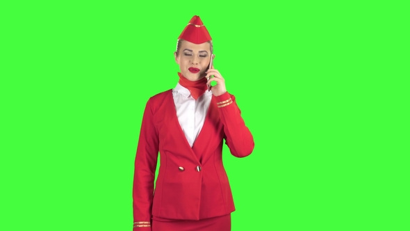 Stewardess Speaks on the Phone and Paces Into the Distance. Green Screen. alt
