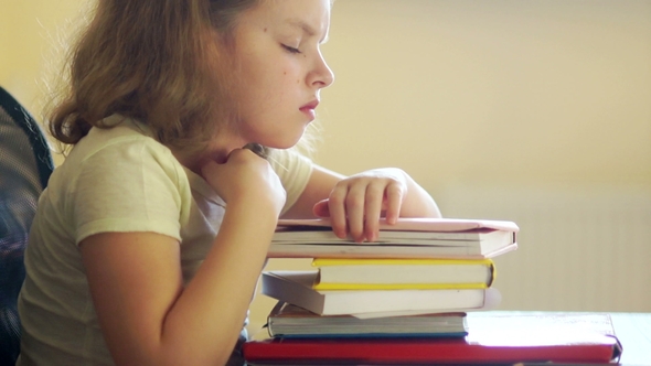 Sad Girl Sitting at the Table with a Pile of Books. Problems of School Education. Back To School