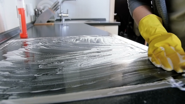 Video of Young Woman in Yellow Rubber Gloves Cleaning Electric Induction Stove with Deteregnt Suf alt