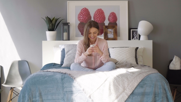 Girl with Mobile Phone in Bed