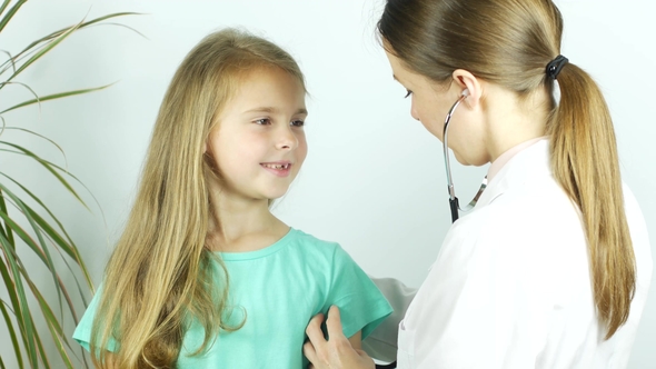 Friendly Pediatrician Doctor Examines a Girl with Stethoscope Checking Lungs alt