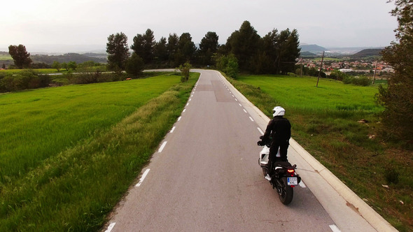Motorcyclist Driving his Enduro Motorbike on a Curvy Road