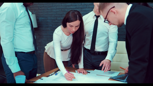 Business People Working Together on a Document During a Meeting in an Office alt