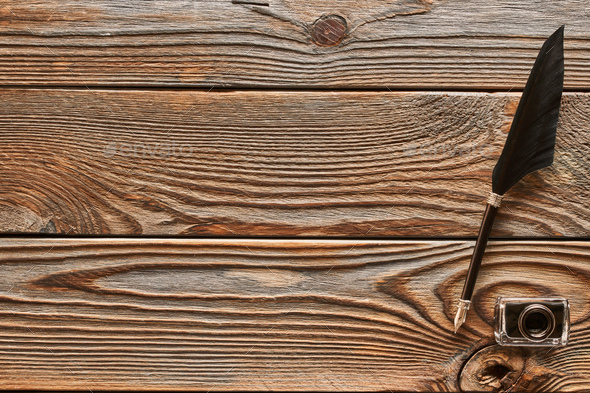Feather pen and inkwell on wooden background Stock Photo by haveseen